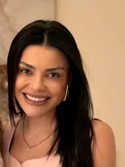 Dra. Isabella Mota sorrindo, de vestido rosa